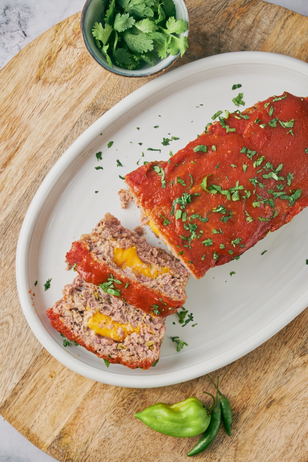 Meatloaf covered in red sauce with two slices cut and laid on top of each other. The meatloaf is filled with melted cheese.