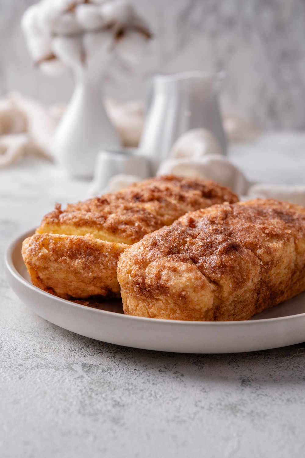 Two baked loaves of cinnamon bread on a white dish