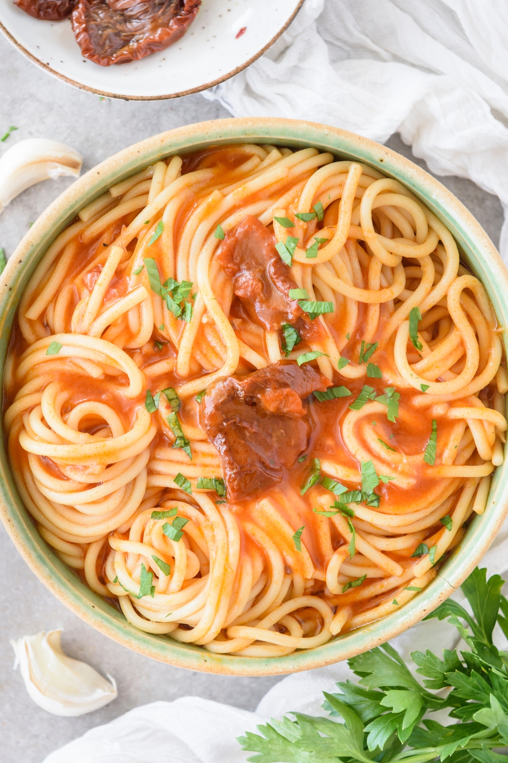 A bowl of spaghetti noodles covered in tomato sauce.