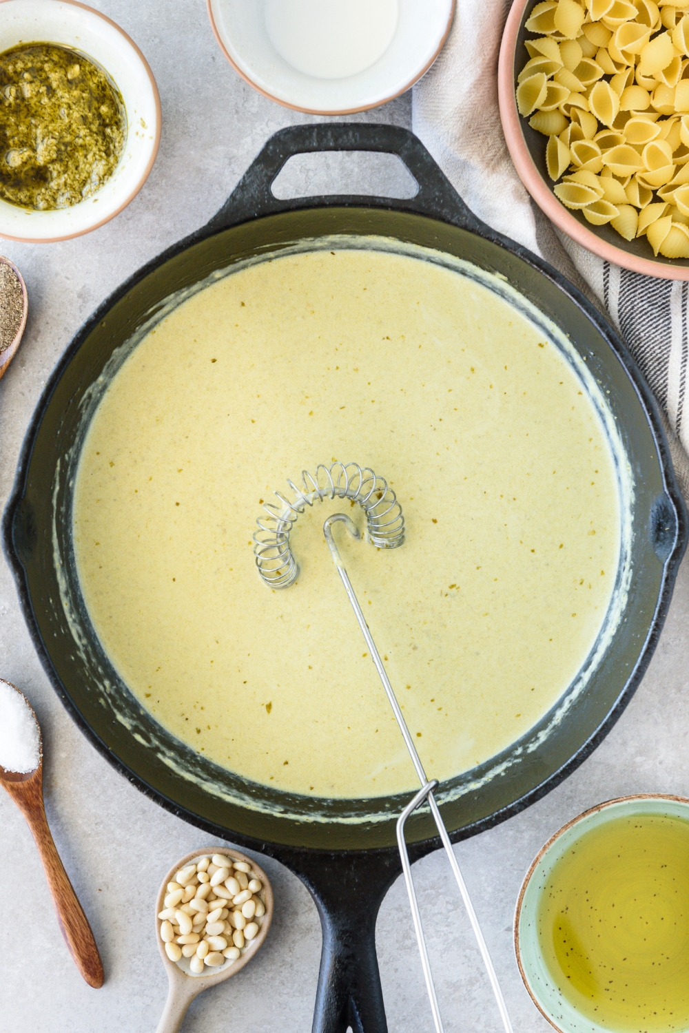 A skillet with creamy pesto sauce.