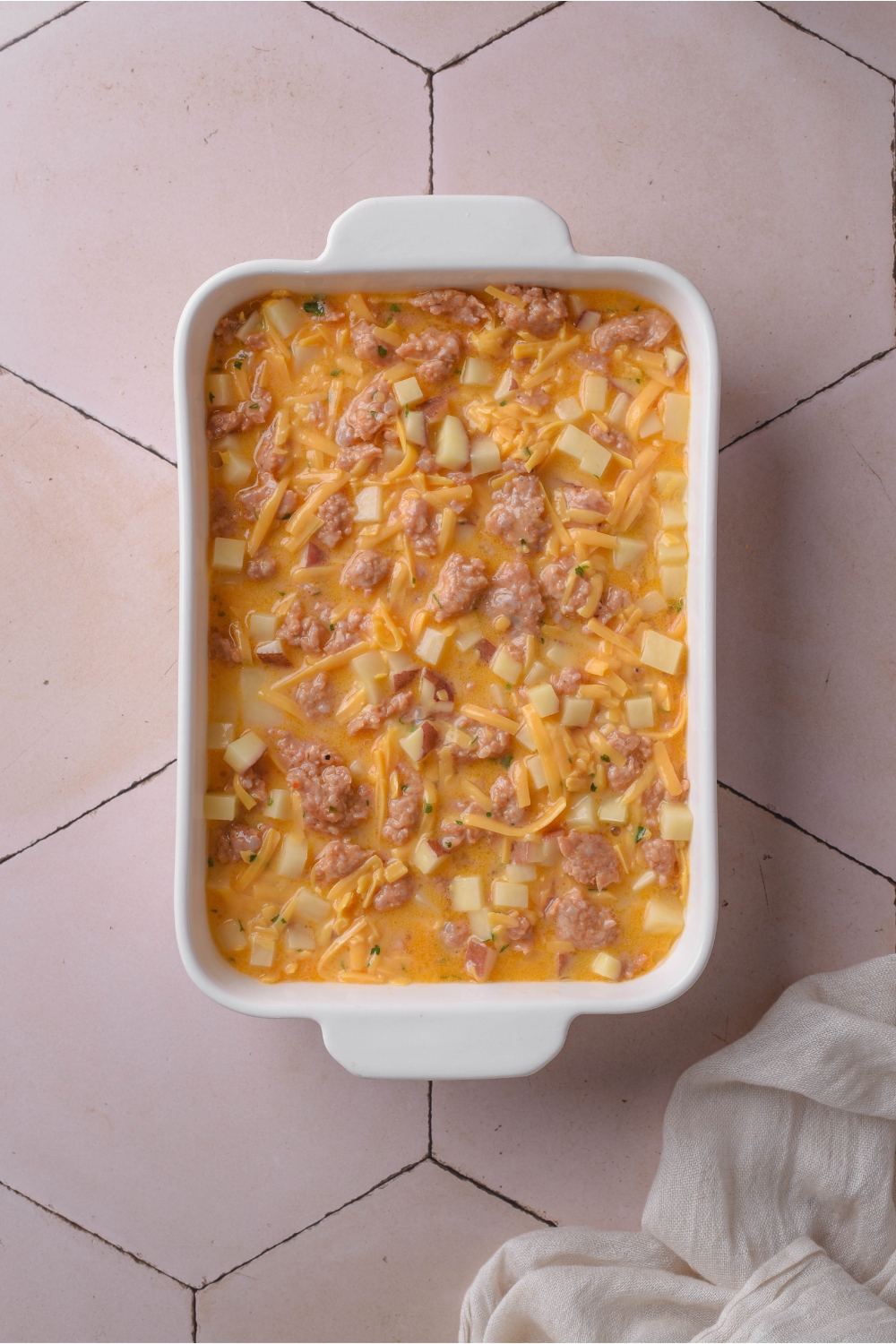 A casserole dish with unbaked hash brown casserole.