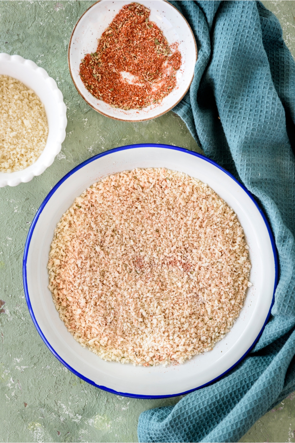 A shallow bowl filled with a seasoned breadcrumb mixture.