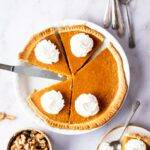 A sweet potato pie in a dish with half the pie and three slices in it.