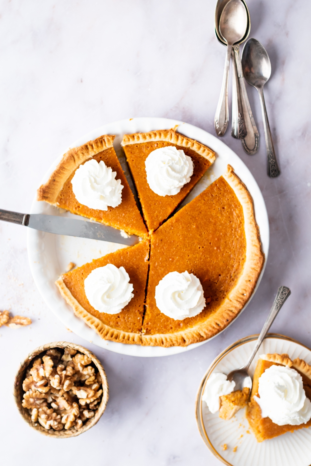 A sweet potato pie in a dish with half the pie and three slices in it.