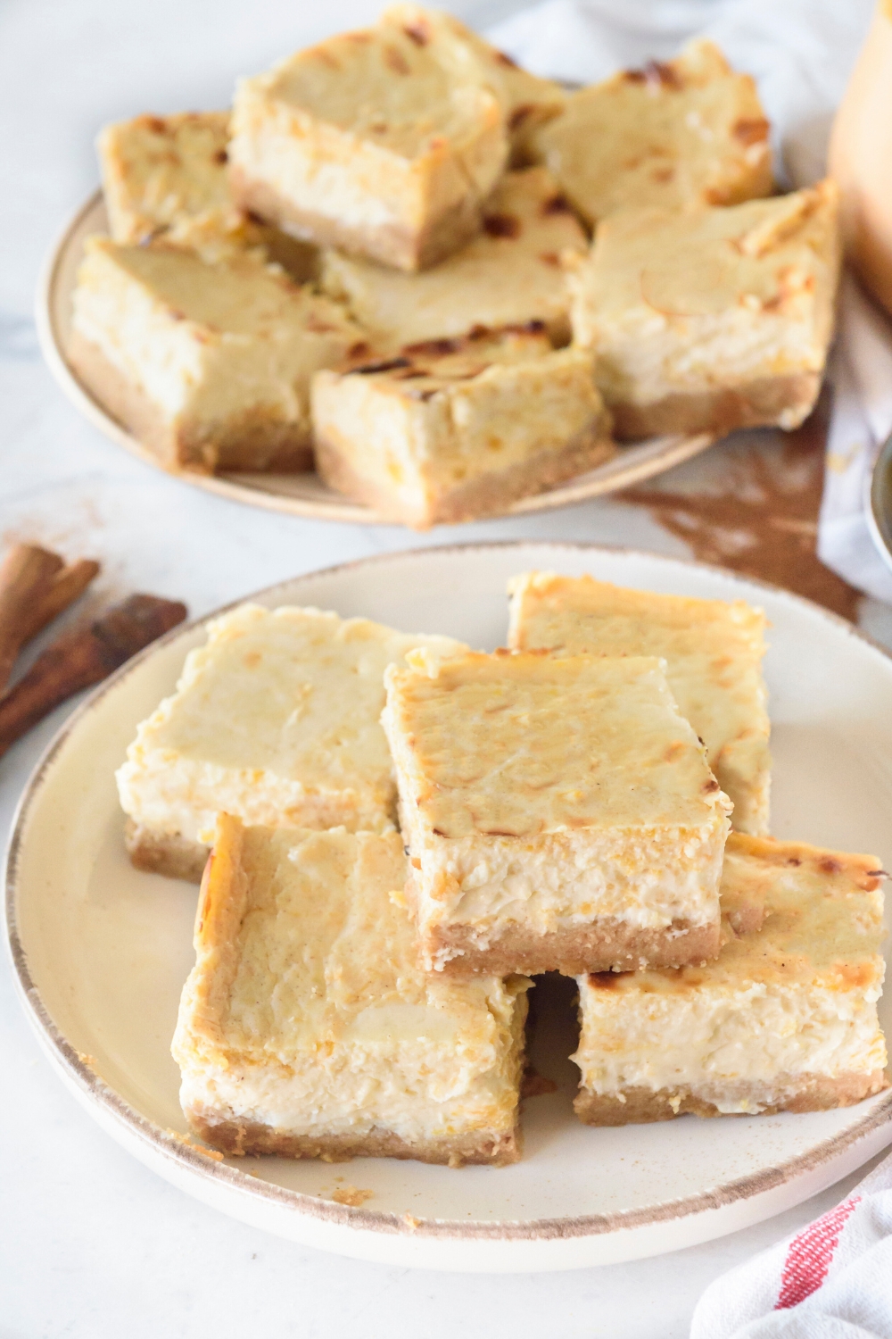 A plate full of pumpkin cheesecake bars.