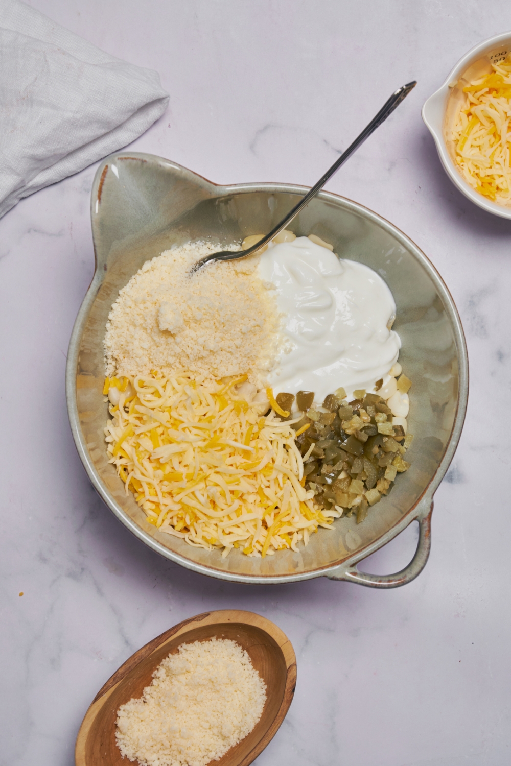 Ingredients for hominy casserole in a silver mixing bowl