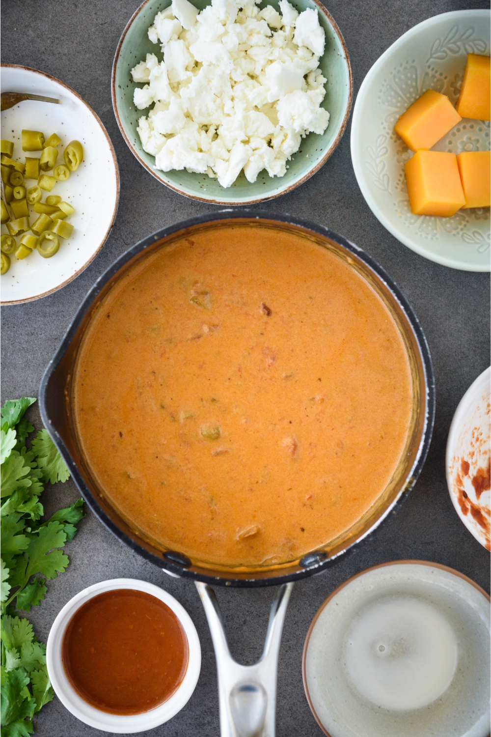 A sauce pot with all the ingredients blended into a smooth queso dip.