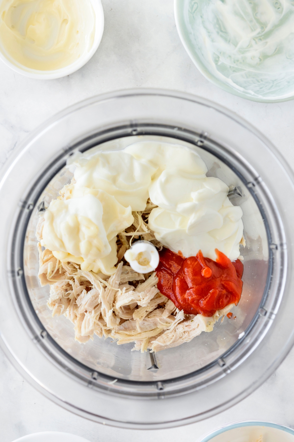 Sour cream, mayo, hot sauce, and shredded chicken in a food processor.