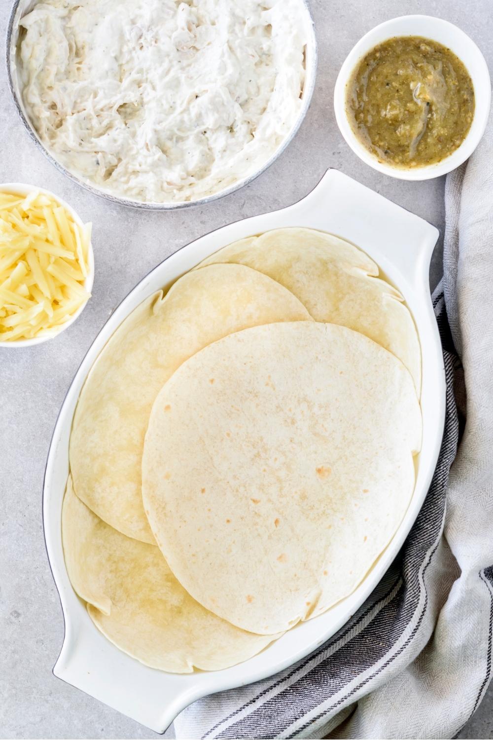 A casserole dish with a layer of flour tortillas