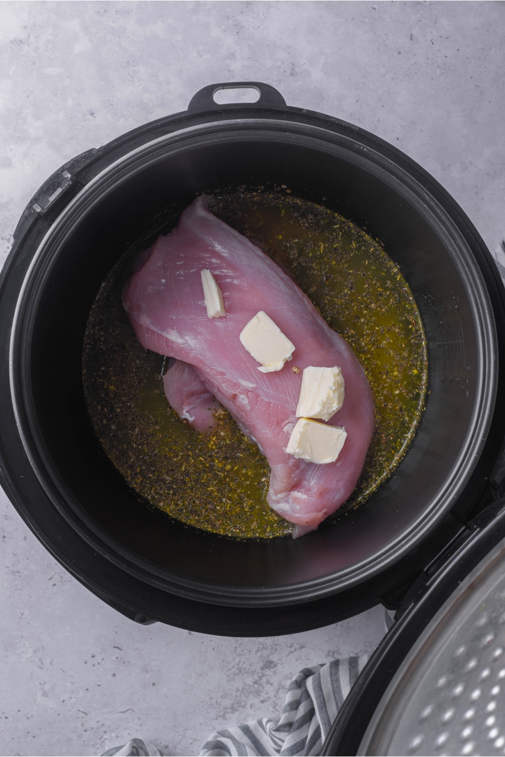 Butter on top of turkey tenderloin in a crock pot with broth.
