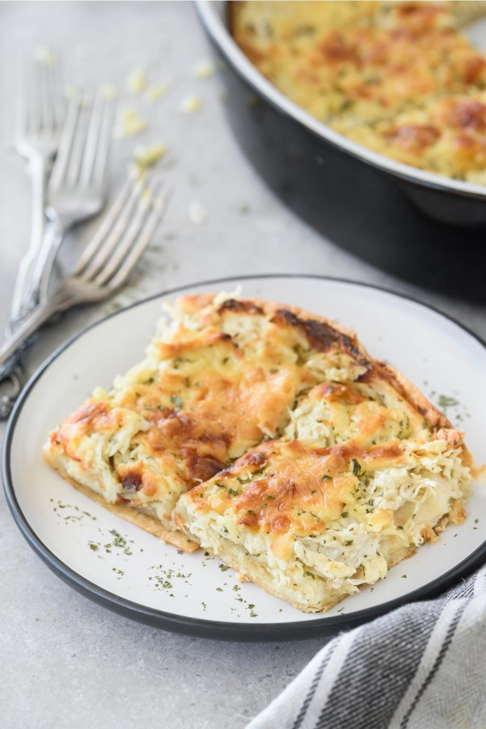 A plate with two squares of green chicken enchilada casserole.