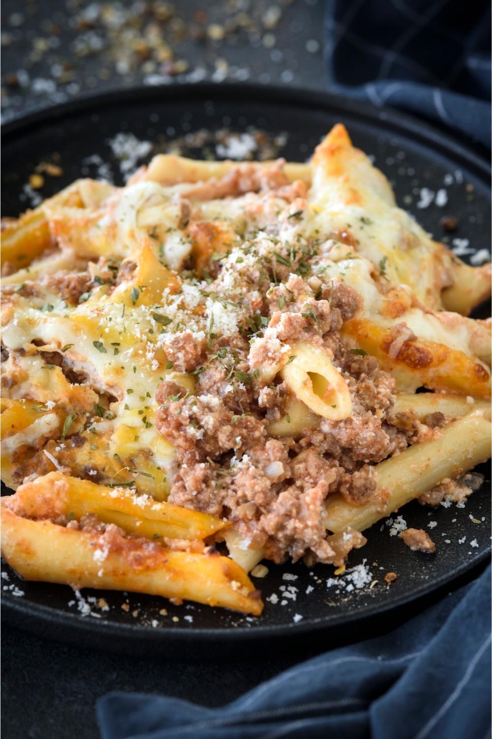 A plate with lasagna casserole topped with parmesan cheese.