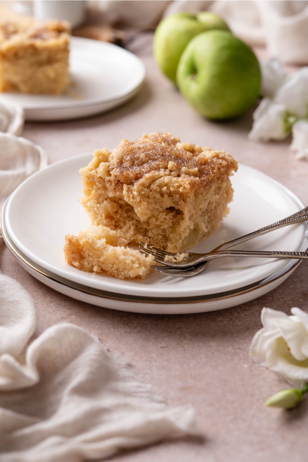 A plate with Apple Coffee Cake and two forks next to it.
