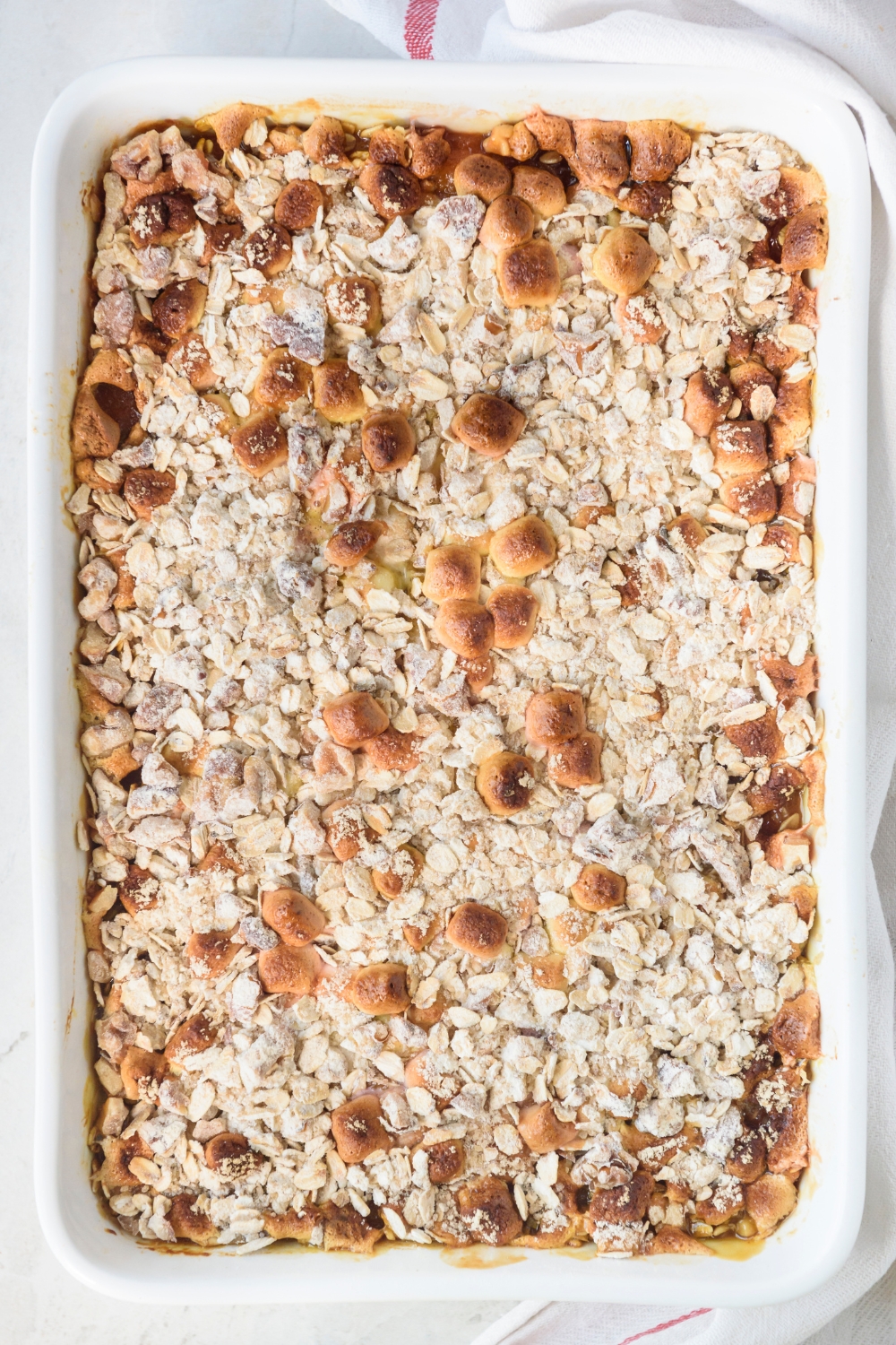 A fully cooked sweet potato casserole in a white casserole dish.