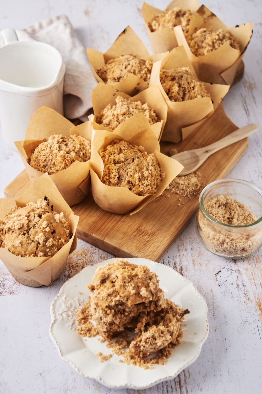 Cinnamon streusel muffins on a serving board with some on a serving plate.