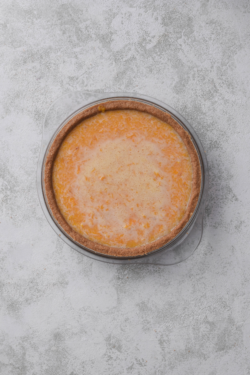 A pie pan with an unbaked pumpkin in it.