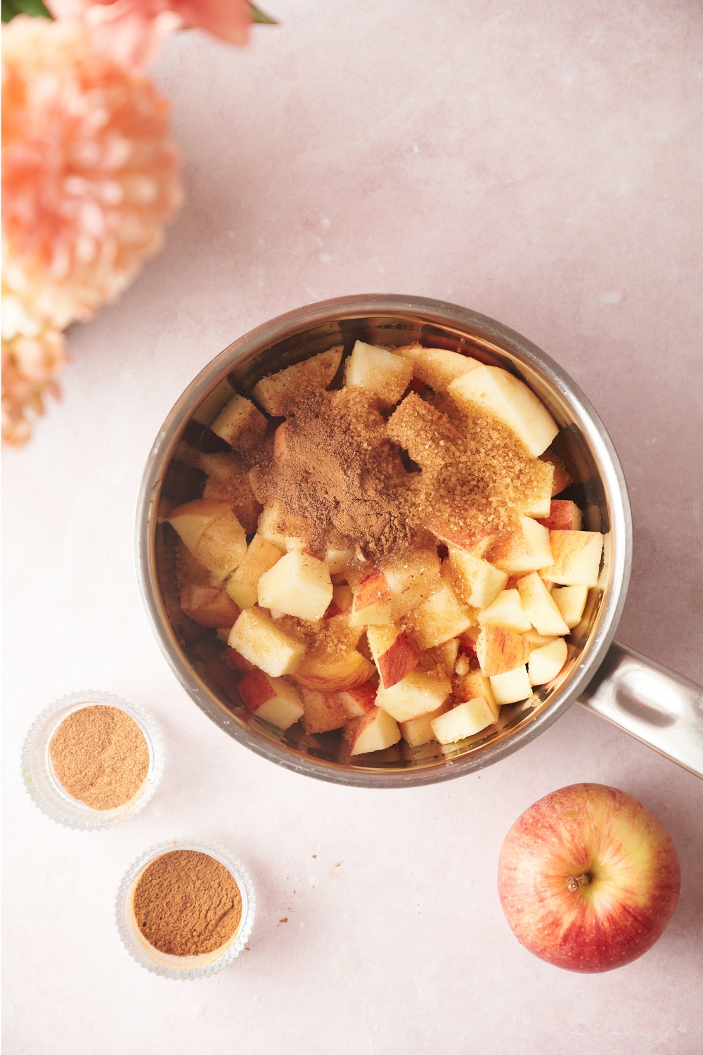A pot with diced apples and seasonings.