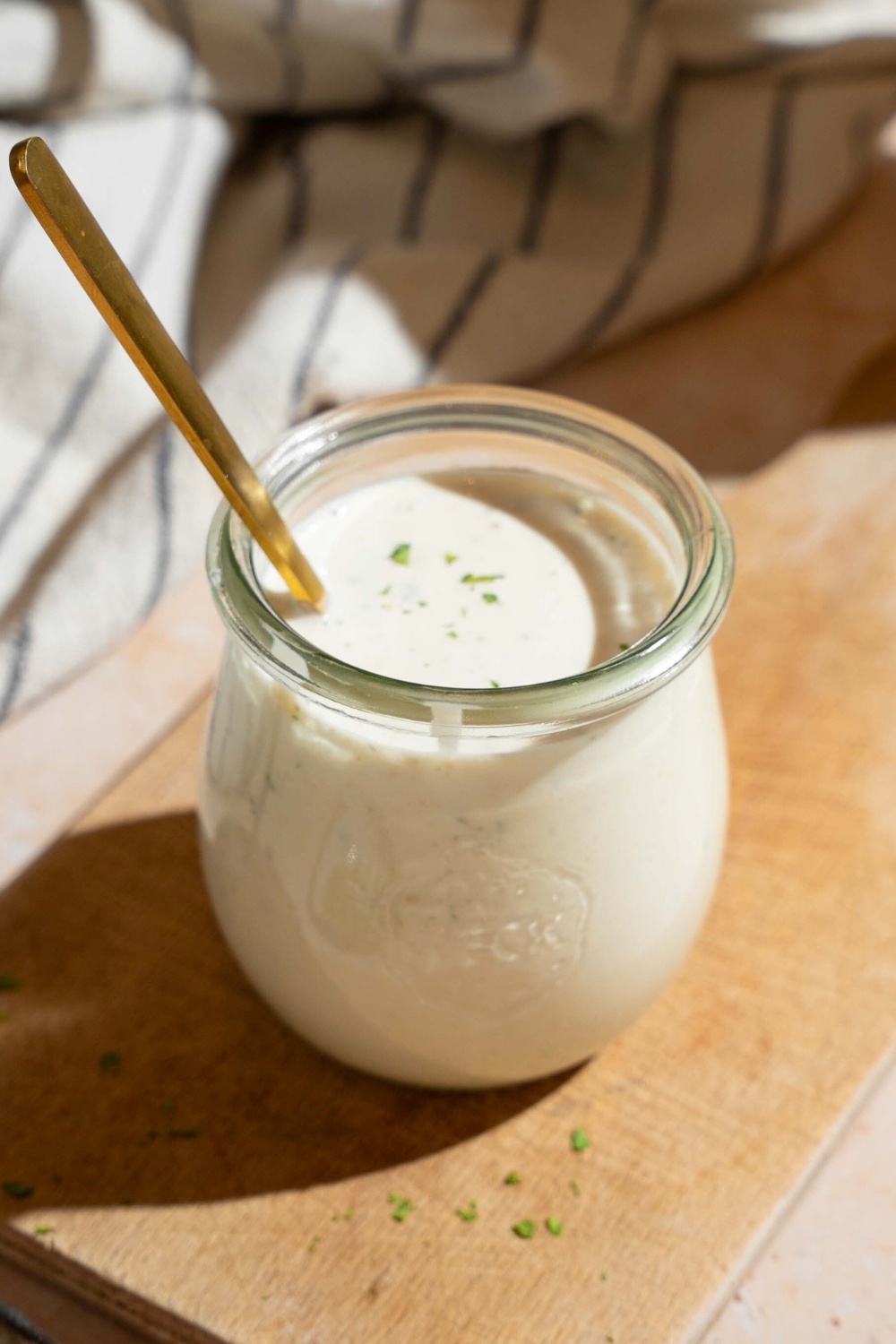 A jar of wingstop ranch dressing with a spoon submerged in it.