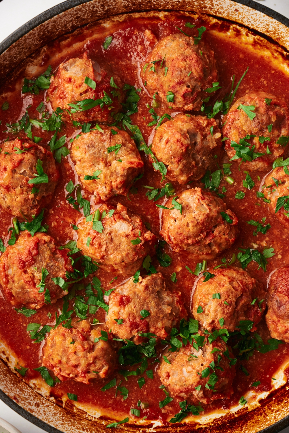 a pot of cooked meatballs in a pot of red sauce