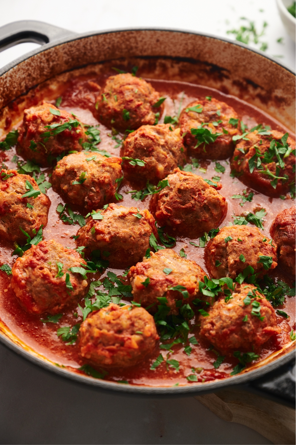 a pot of cooked meatballs in red sauce