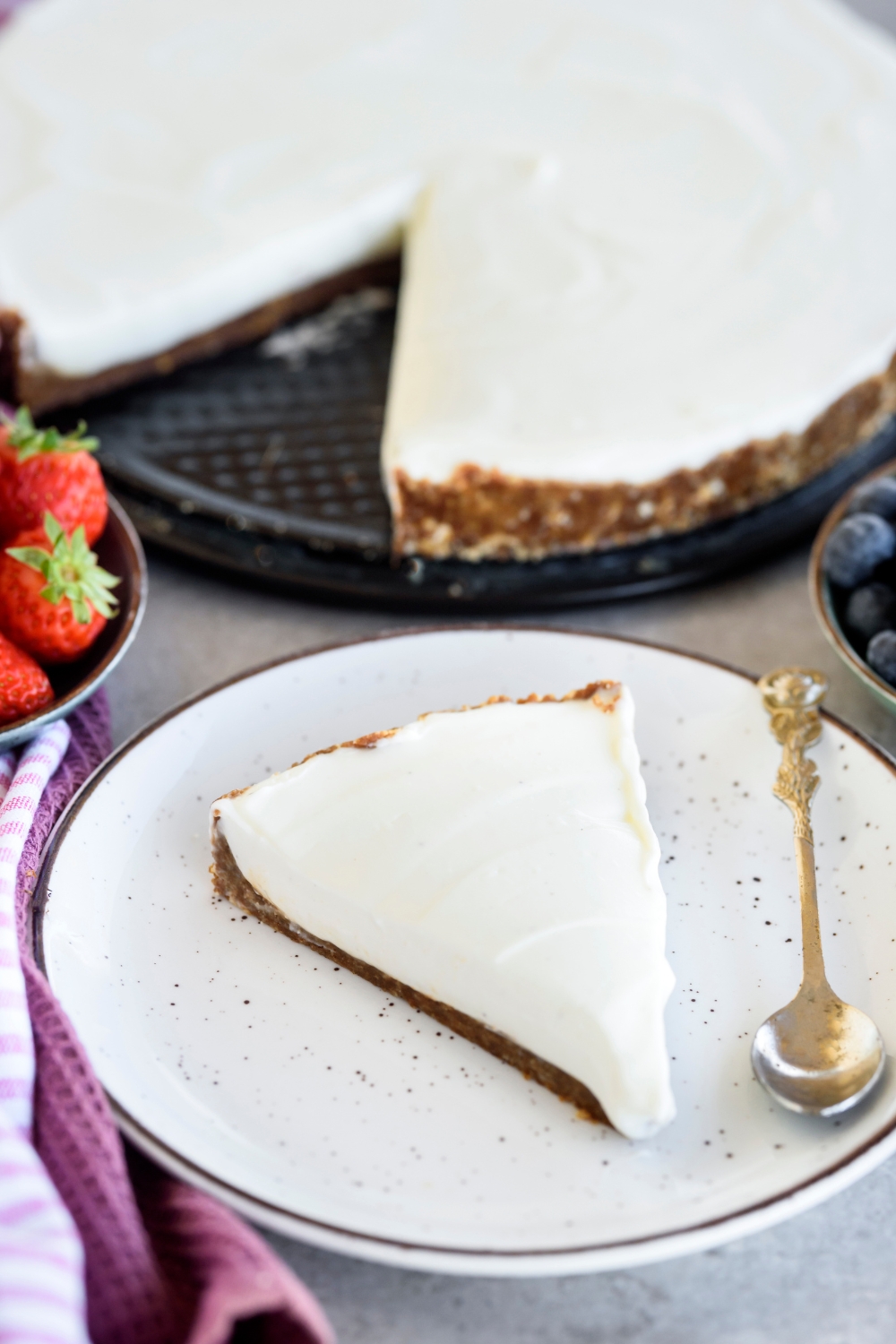 A slice of Cool Whip pie on a plate with a spoon on the plate and the rest of the pie is in the background.