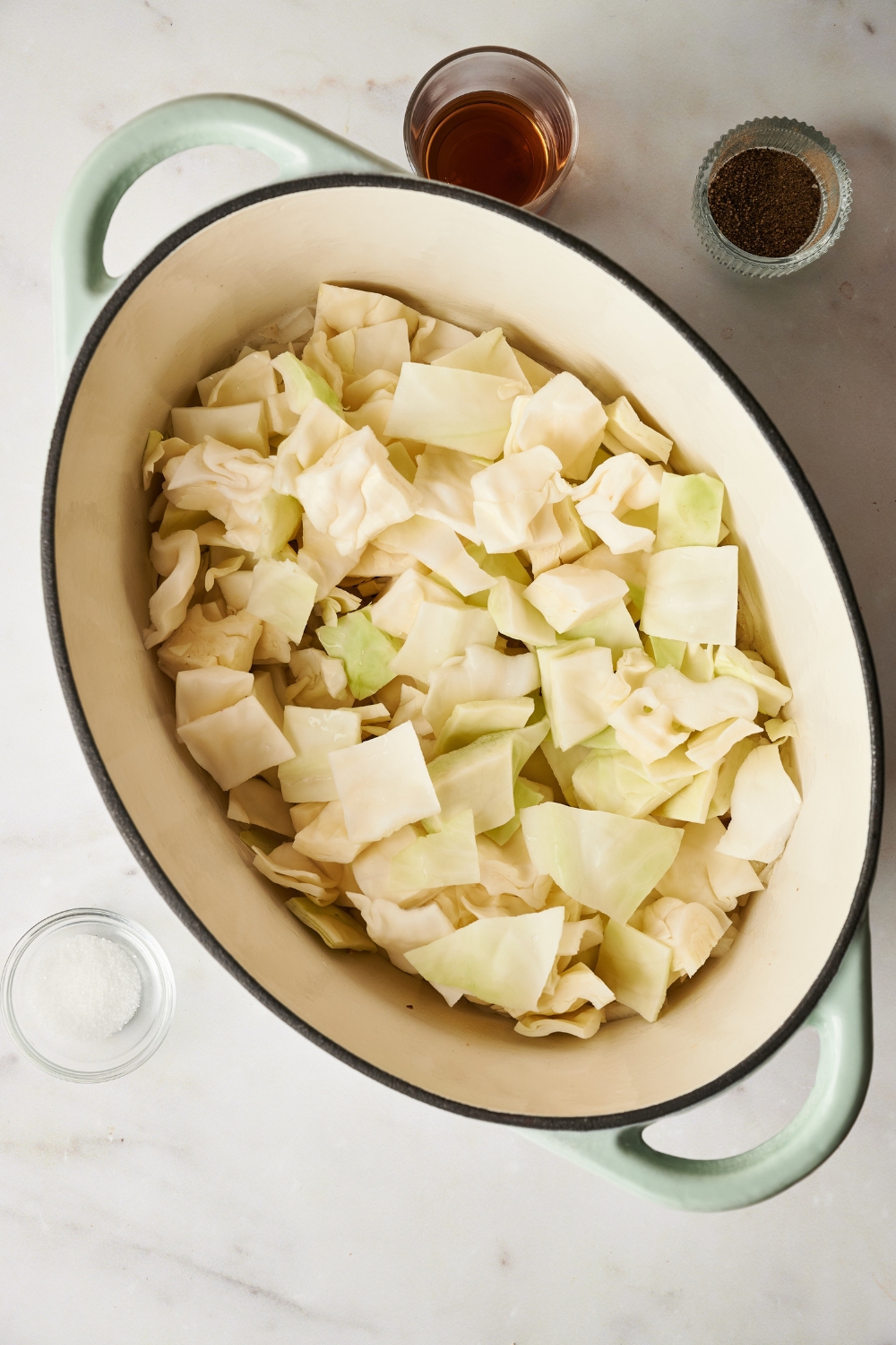 A Dutch oven with diced cabbage cooking in it.