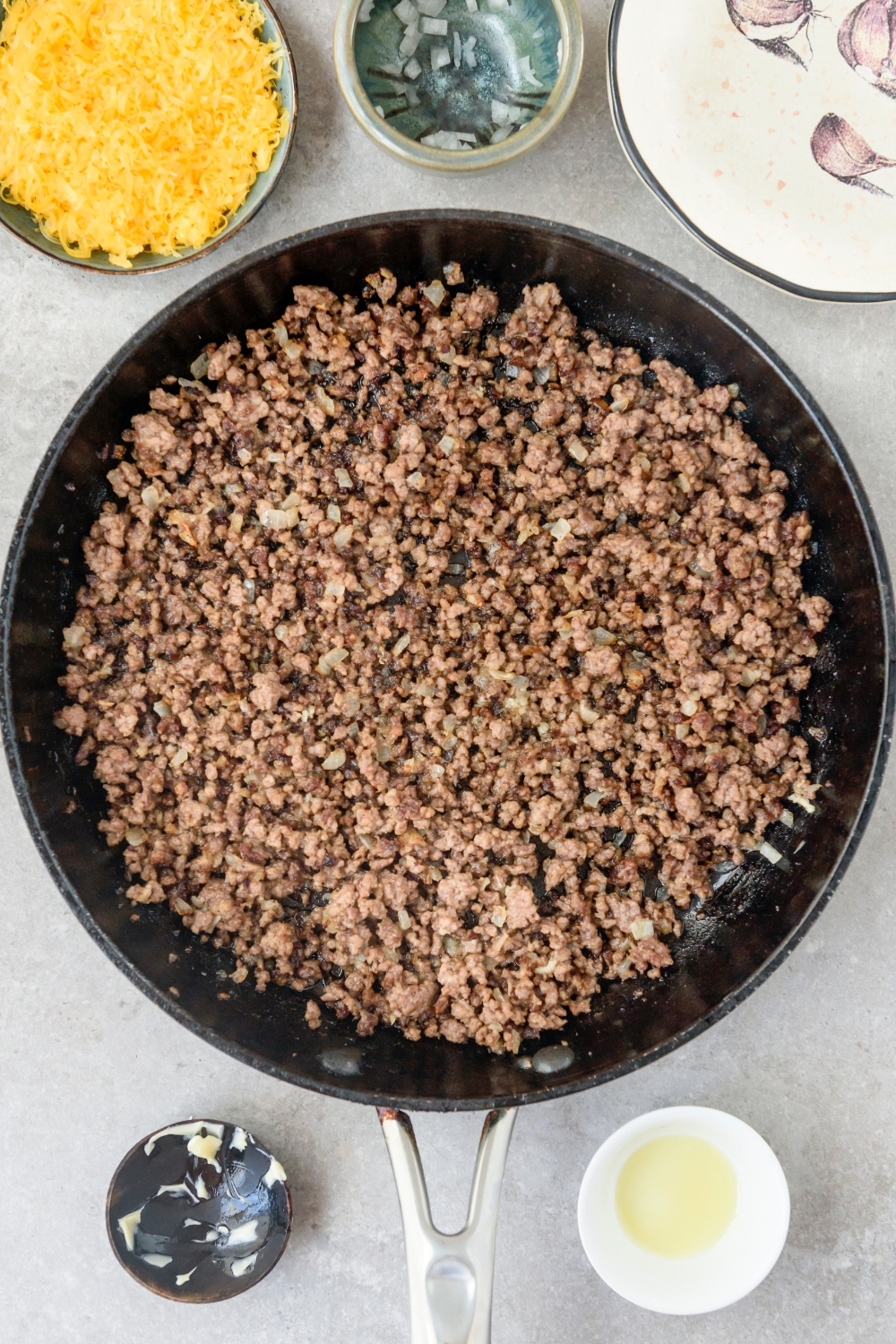 A skillet with cooked ground beef in it.