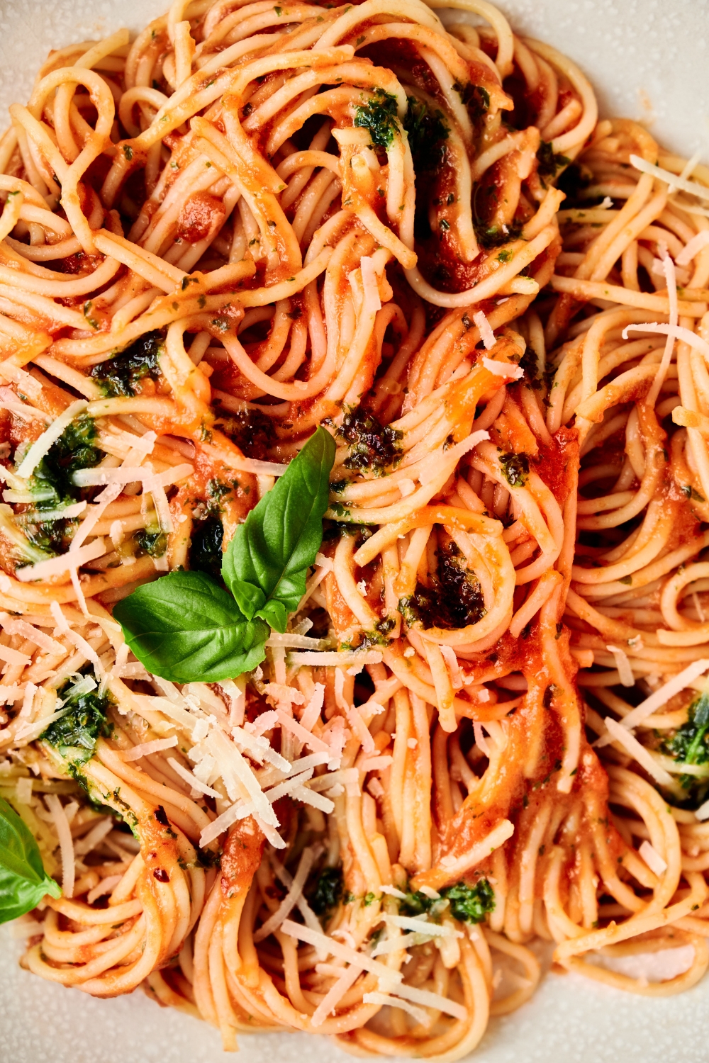 A bowl of spaghetti pomodoro garnished with fresh herbs and Parmesan cheese.