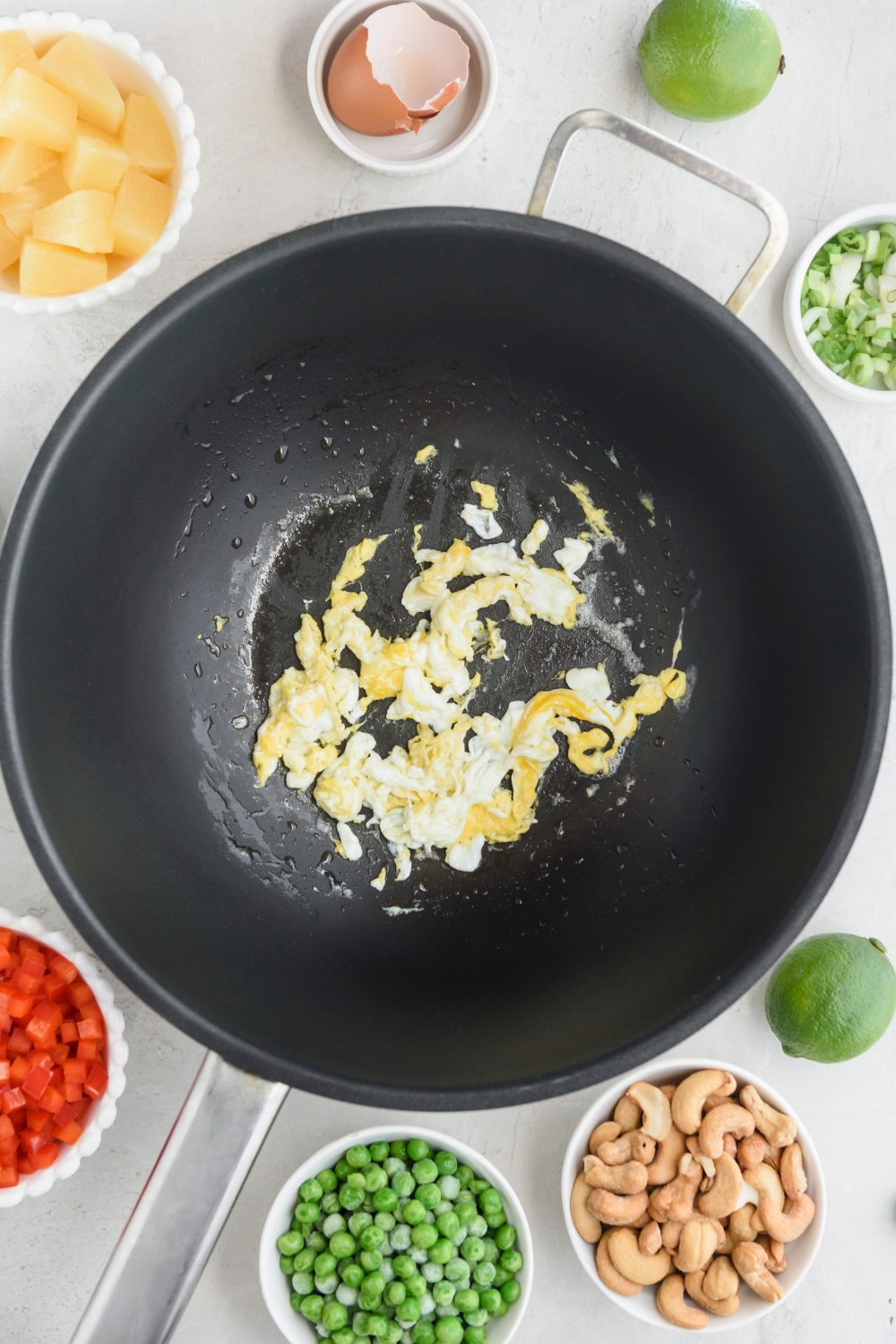 A wok with scrambled egg cooking.