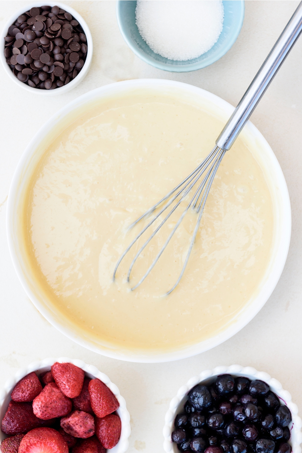 A mixing bowl with pancake batter in it.