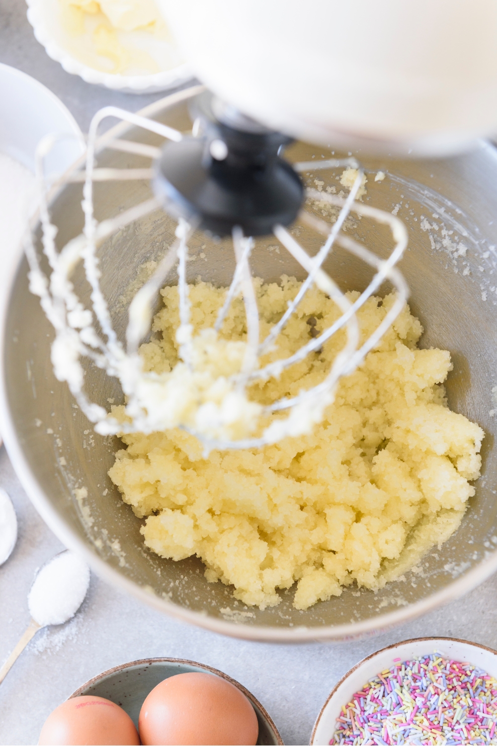 A mixing bowl with creamed butter and sugar.