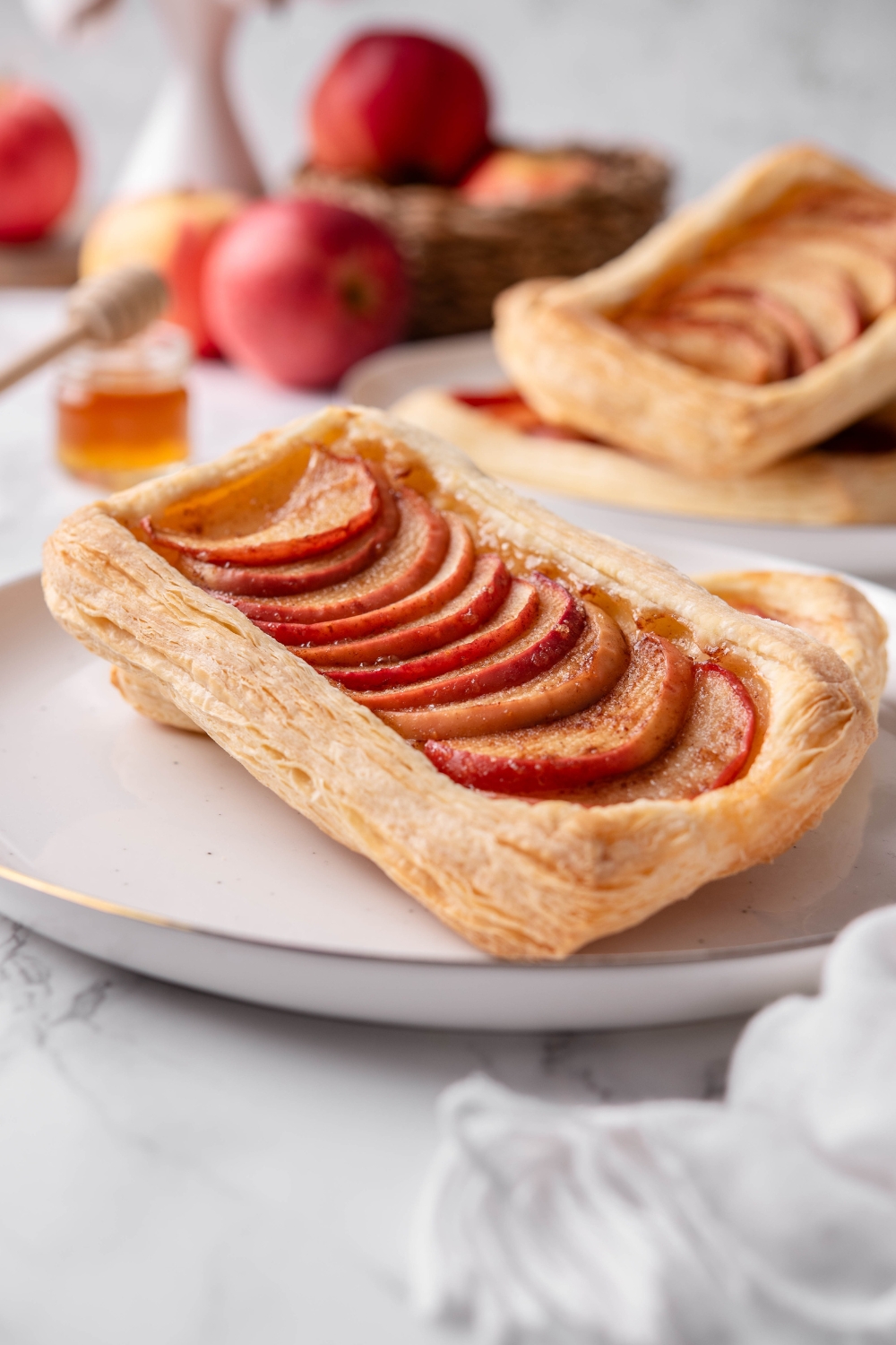 An apple puff pastry with apples overlapping one another in the middle of the pastry dough.
