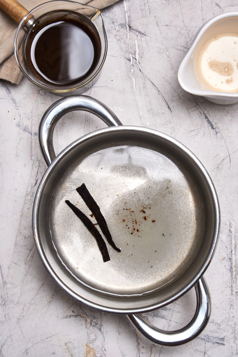 A sauce pot with the vanilla beans toasting.