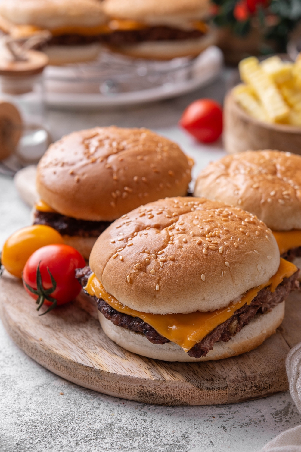 Three white castle sliders sit on a wooden serving board.
