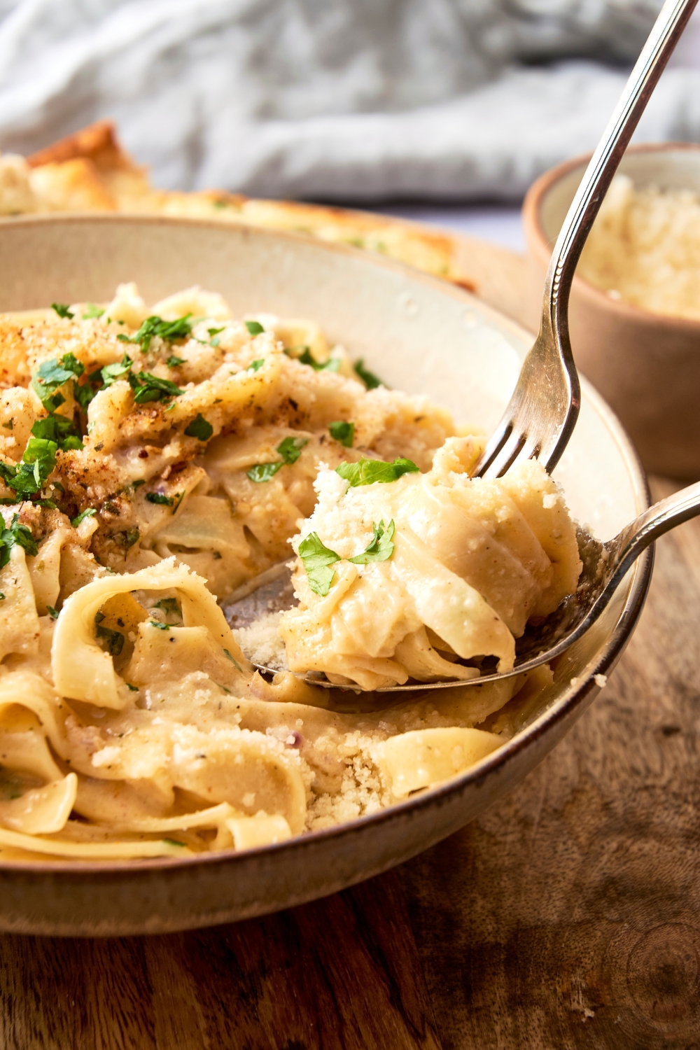 Someone twirls fettuccine around a fork in a bowl full of Cajun Alfredo.