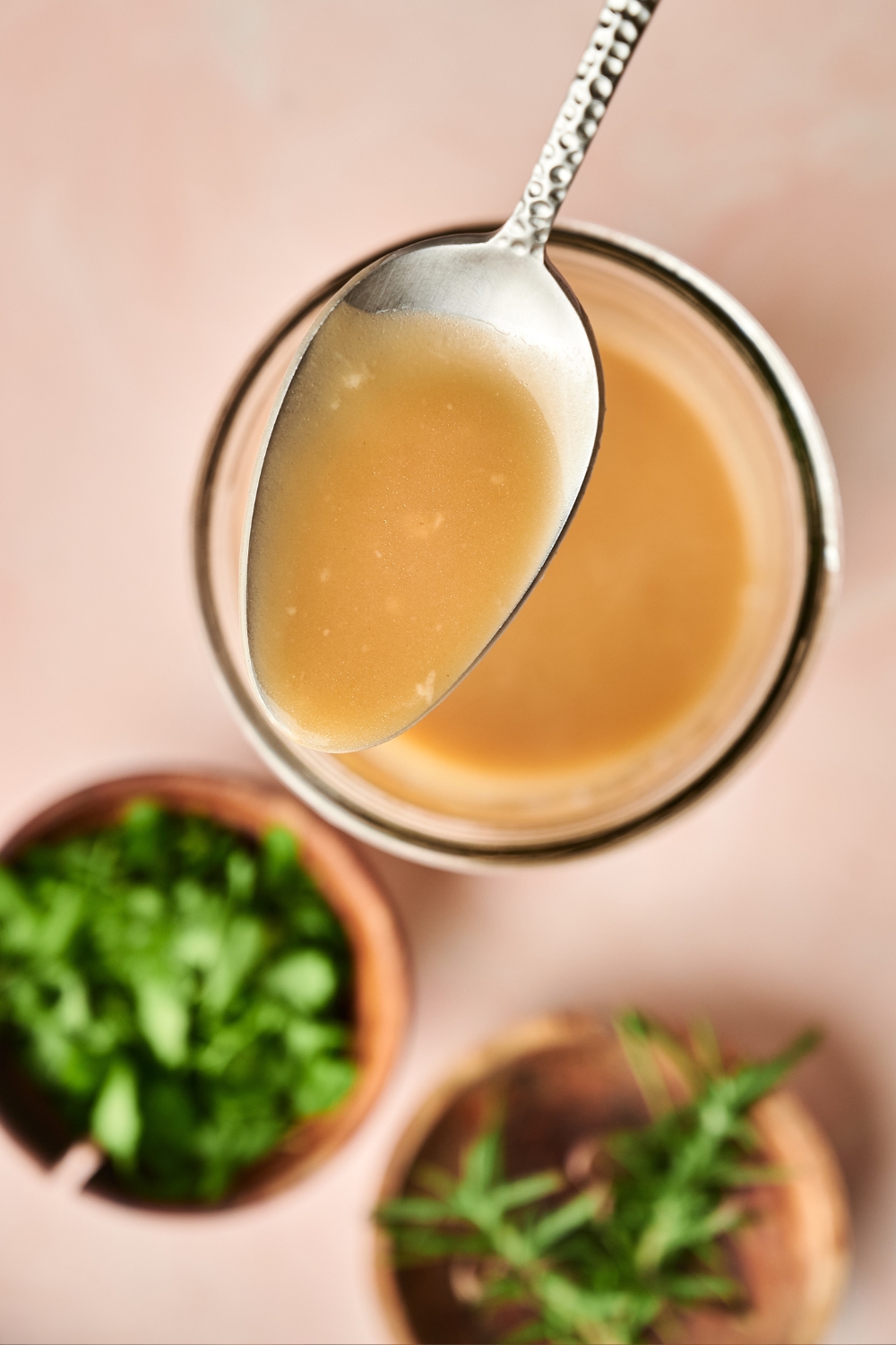 A spoonful of gravy hovers over a jar of gravy.