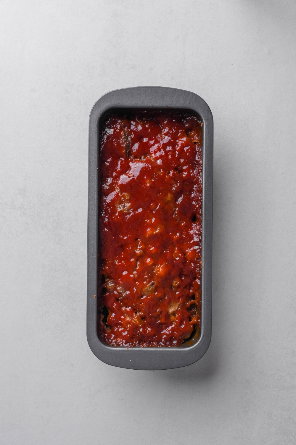 A loaf pan with the cooked meatloaf.