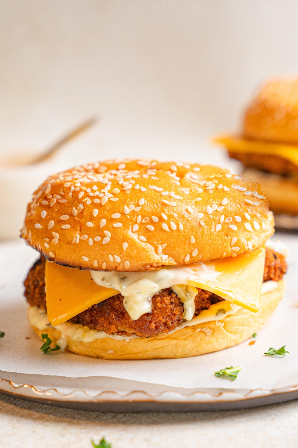 An assembled filet o fish sandwich sits on a white plate.