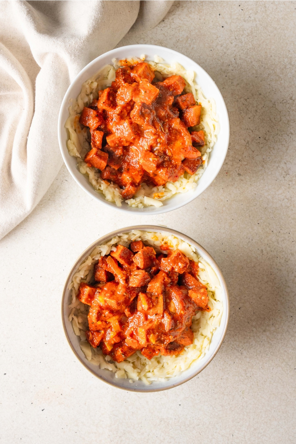 Two bowls hold mozzarella cheese, mushrooms, and tomato-pepperoni sauce.