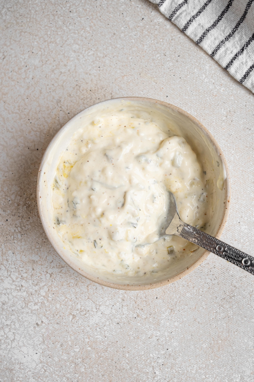 A small bowl holds chunky garlic aioli. A spoon rests in the aioli as well.