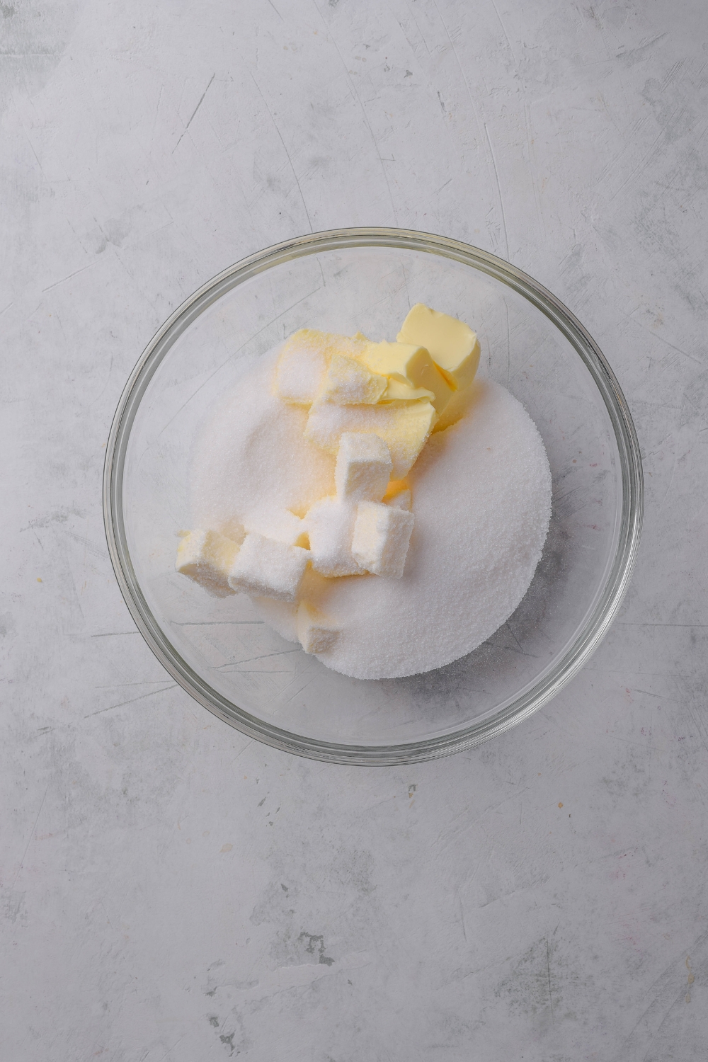 A glass bowl holds sugar, butter, and vegetable shortening.