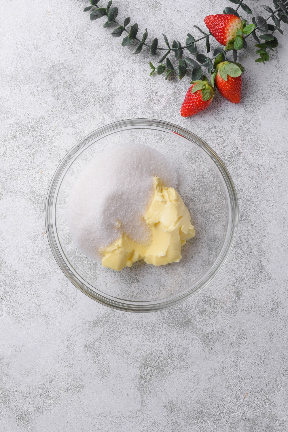 A glass bowl holds butter and sugar.