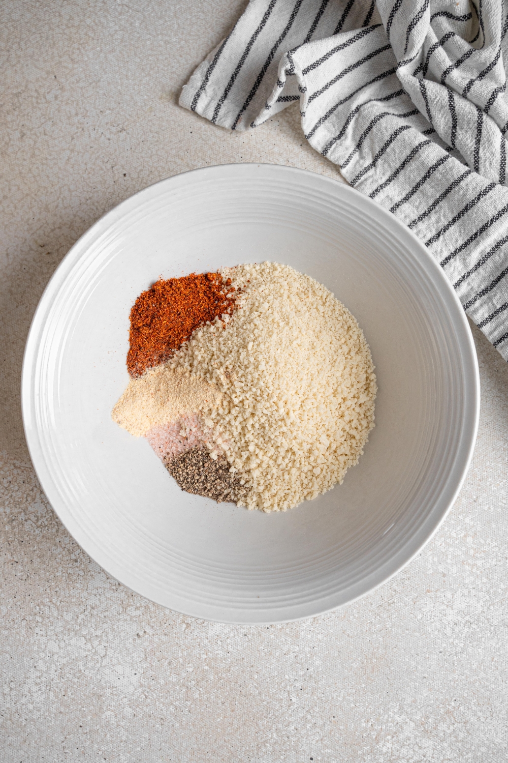 A white bowl holds panko breadcrumbs and seasonings.