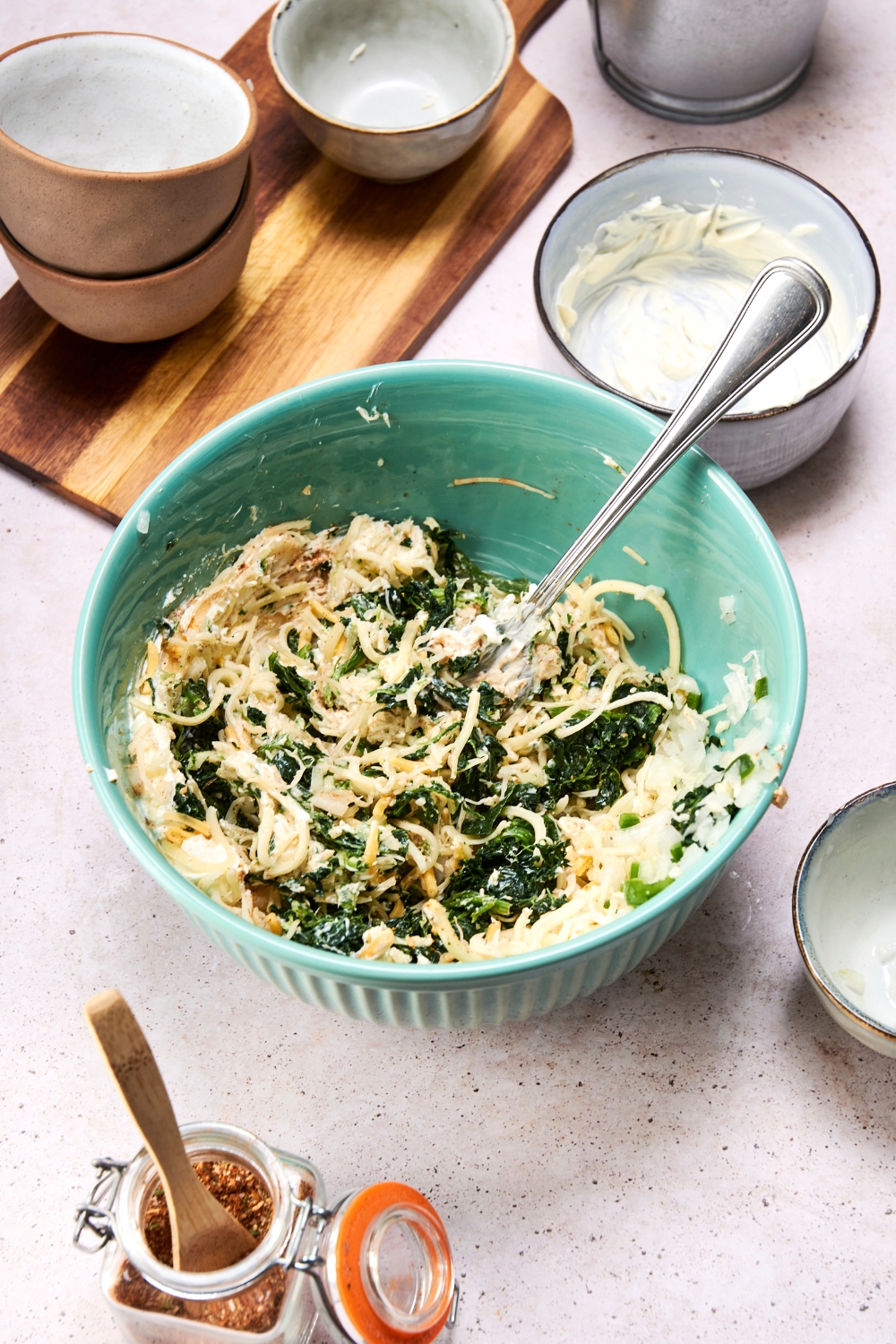 A mixing bowl with the spinach dip ingredients mixed together.