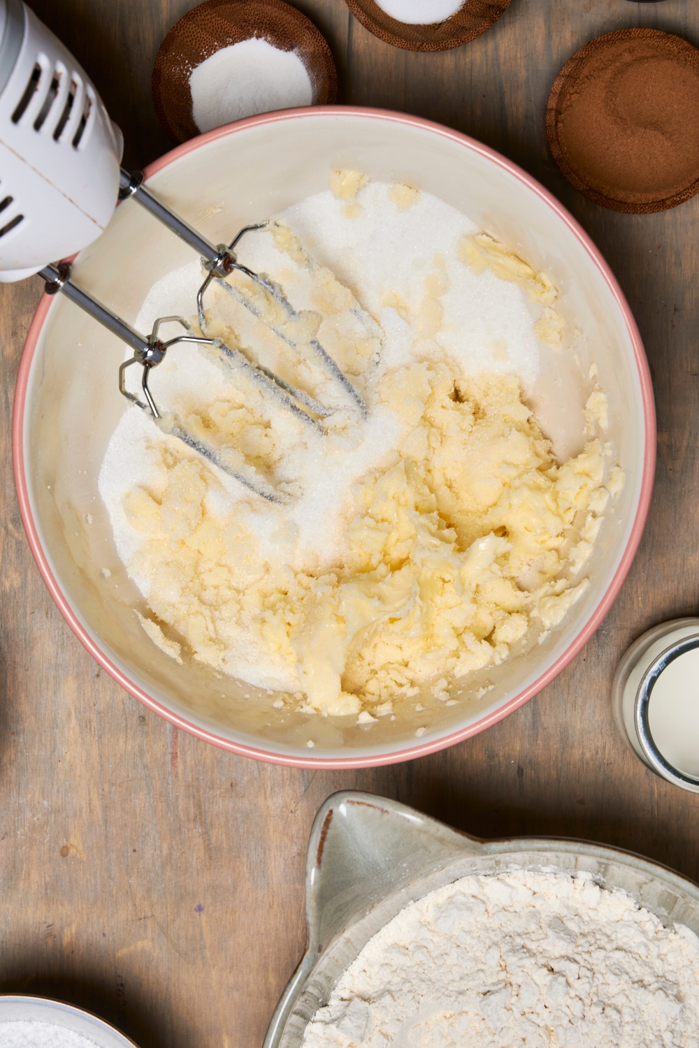 A mixing bowl with an electric mixer creaming the butter and sugar together.
