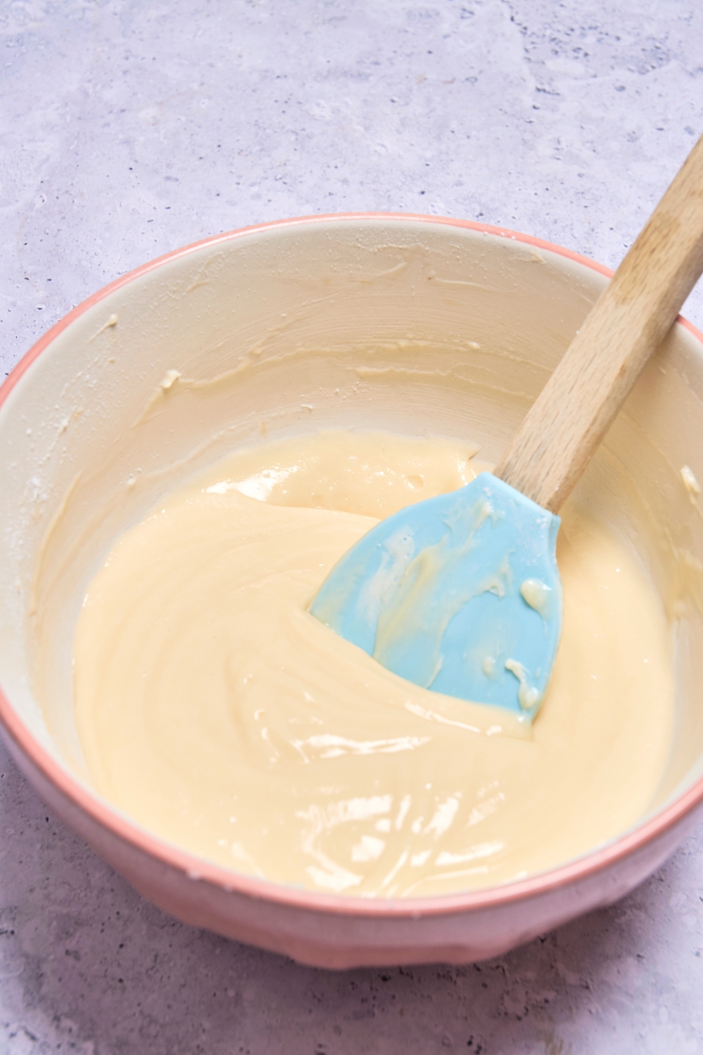 A mixing bowl with cream cheese frosting.