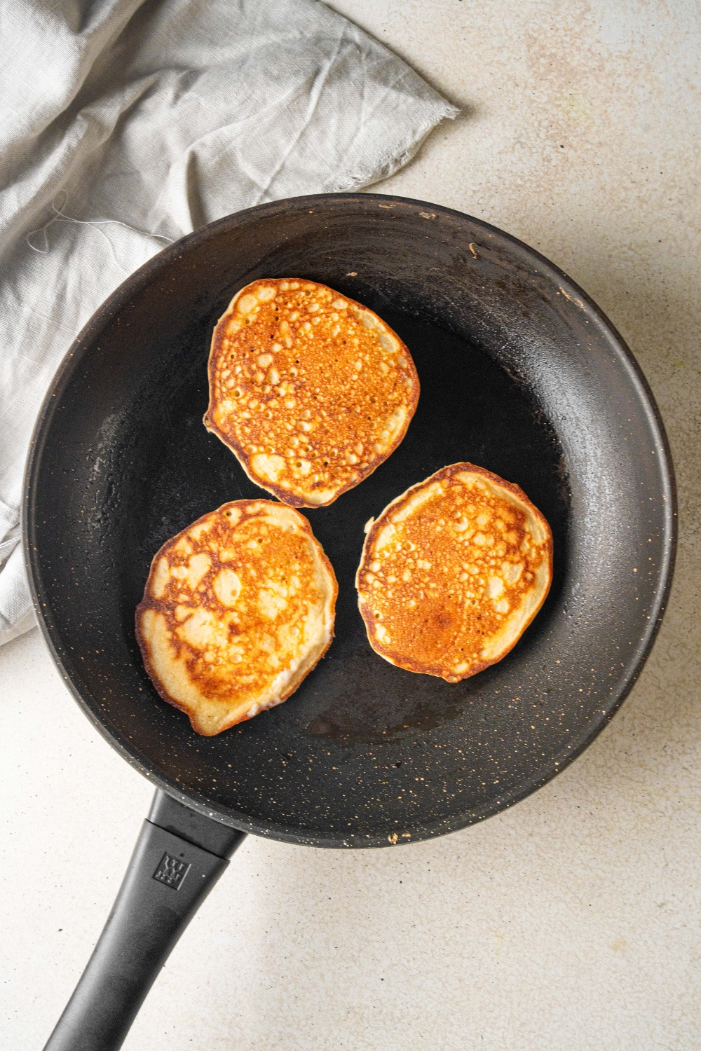 A frying pan with the pancakes cooking.