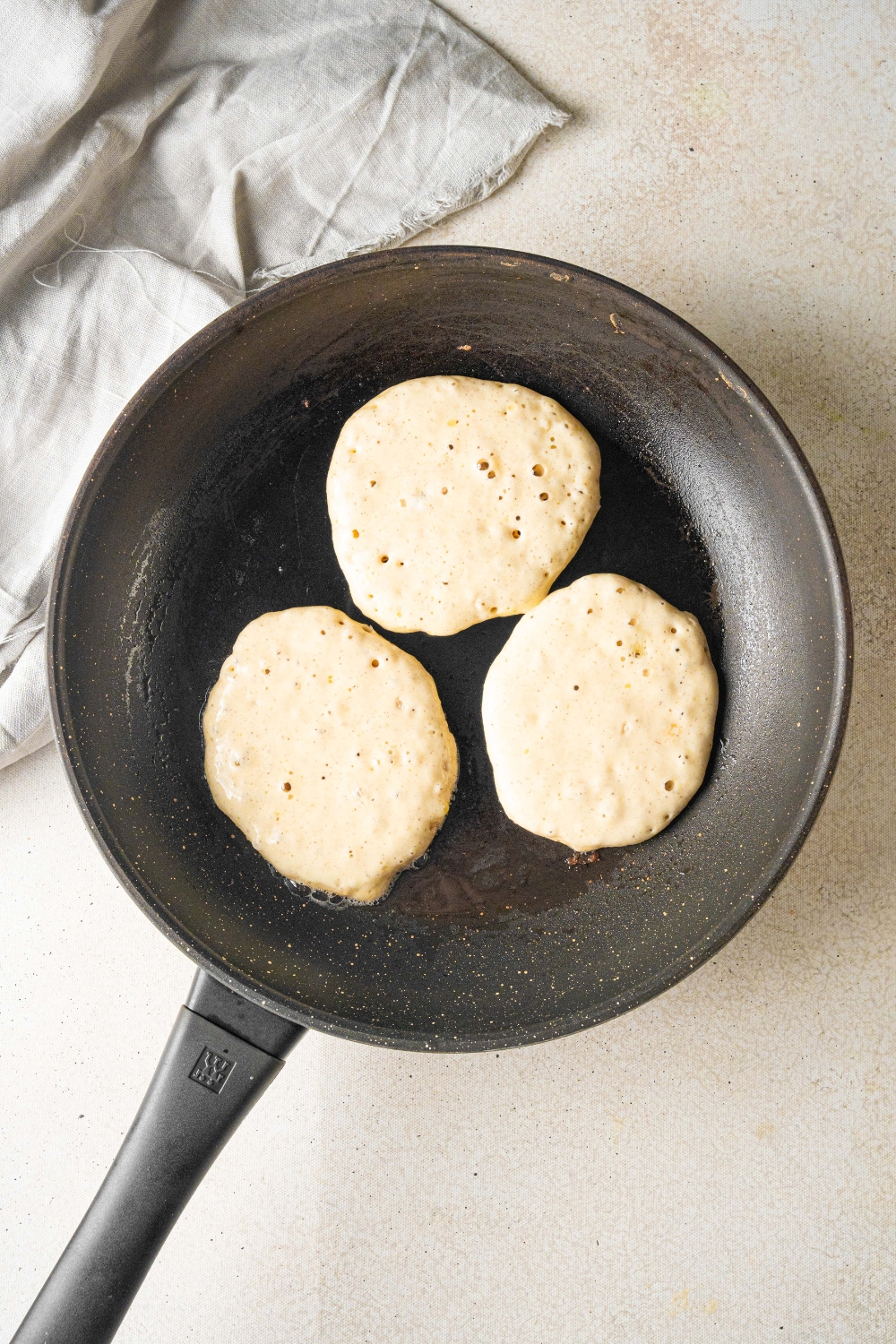 A frying pan with the pancakes cooking.