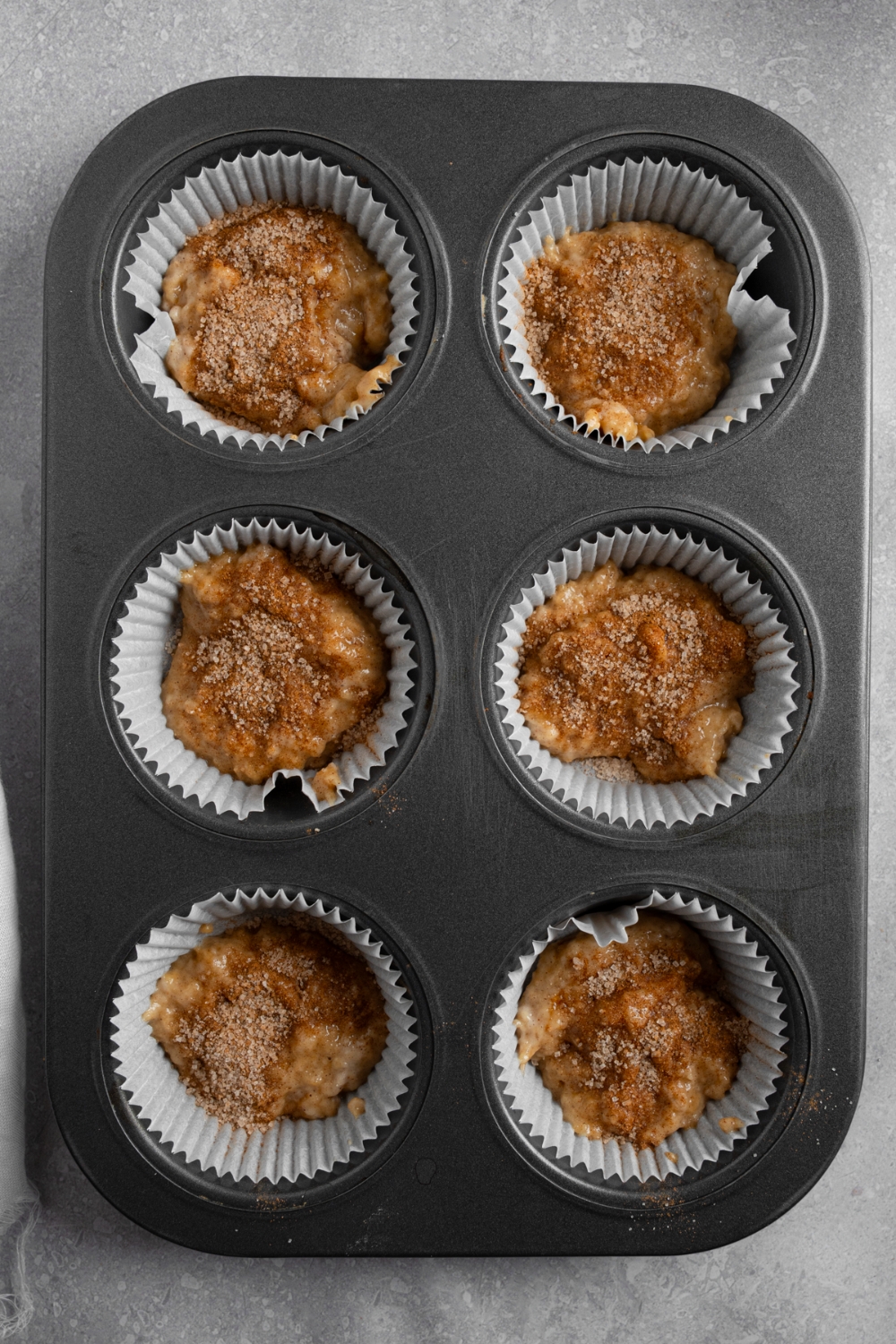 A muffin tray with coffee cake muffin batter.