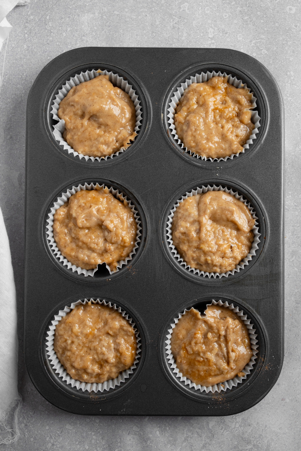 A muffin tray with coffee cake muffin batter.